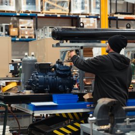 Transom employee assembling a heat pump on production floor